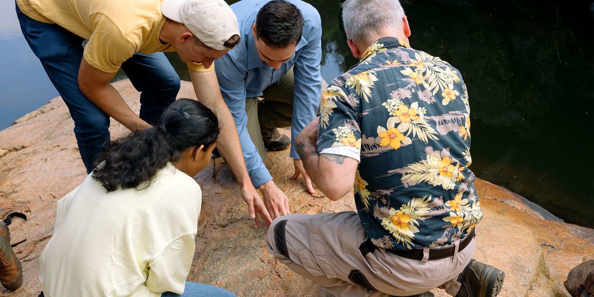 A group of geology students and their professor examining rock formations